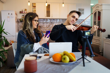 One woman caucasian learning man to holding and play violin in his house at home Mentoring tutoring...