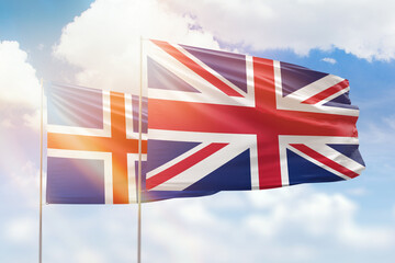 Sunny blue sky and flags of united kingdom and iceland