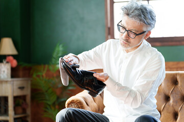 革靴を磨くミドル男性