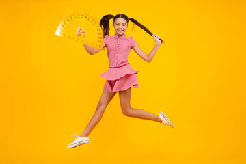 Back to school. School girl hold ruler measuring isolated on yellow background. Happy teenager, positive and smiling emotions of teen schoolgirl.