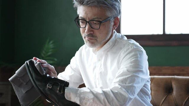 革靴のメンテナンスをするミドル男性