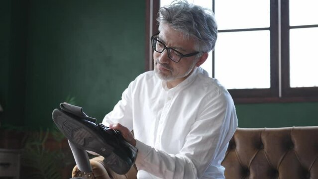 革靴のメンテナンスをするミドル男性