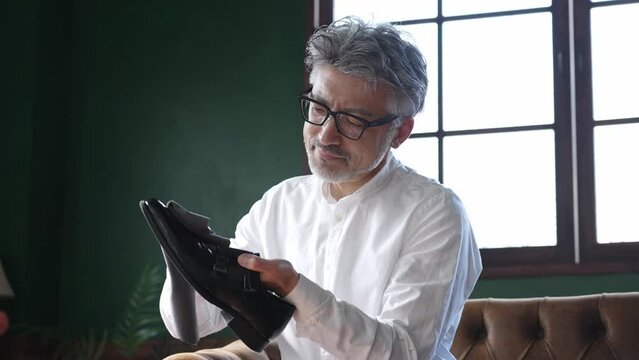 革靴のメンテナンスをするミドル男性