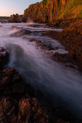 Water flowing between rock formation on the shore.