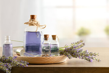 Glass containers with essence of lavender with bouquets in room - obrazy, fototapety, plakaty