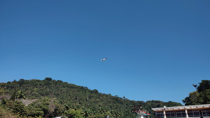 Fototapeta na wymiar landscape horizon hill mountain quarry clear blue sky forest vegetation tree leaves nature close passenger plane