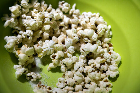 Pop Corn With Too Much Salt In A Green Bowl Close Up