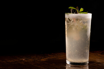 refreshing long juice with mojito foam, mint on wooden table