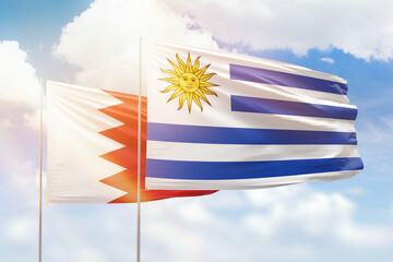 Sunny blue sky and flags of uruguay and bahrain