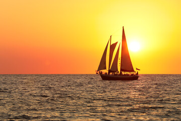 sail boat silhouette in the sun set at the beach - Powered by Adobe