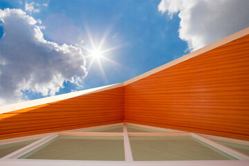 A low angle closeup view of roof upper floors of a house in daytime against blue sky