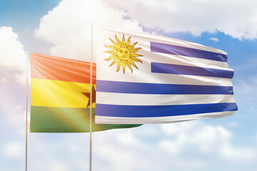 Sunny blue sky and flags of uruguay and ghana