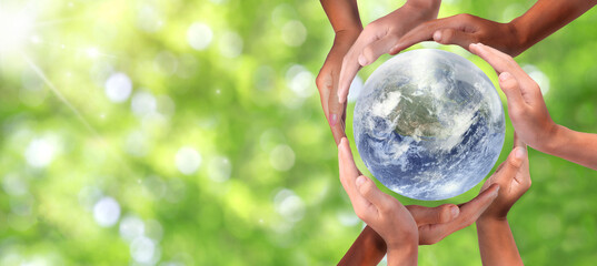 Conceptual symbol of multiracial human hands surrounding the Earth globe. Unity, world peace, humanity concept. World environment day