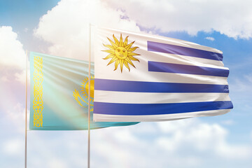 Sunny blue sky and flags of uruguay and kazakhstan