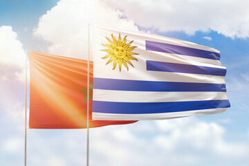 Sunny blue sky and flags of uruguay and morocco