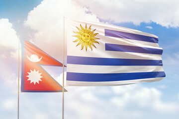 Sunny blue sky and flags of uruguay and nepal