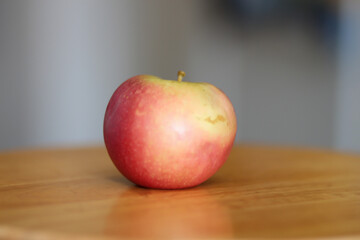 pink lady apple on wooden stool
