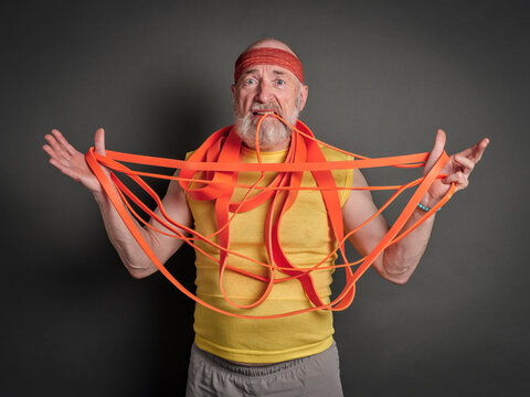 confused senior man with a bunch of resistance bands, fitness over 60 concept