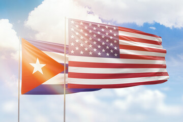 Sunny blue sky and flags of united states of america and cuba