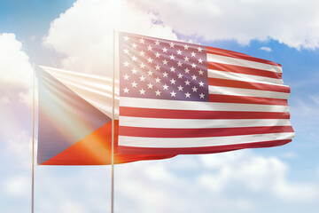 Sunny blue sky and flags of united states of america and czechia