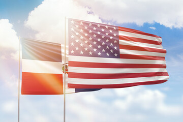 Sunny blue sky and flags of united states of america and dominican republic