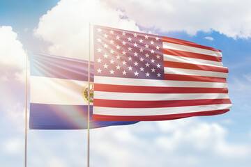 Sunny blue sky and flags of united states of america and el salvador
