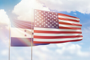 Sunny blue sky and flags of united states of america and honduras