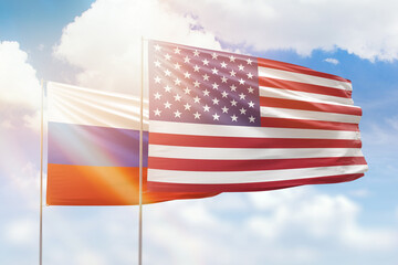 Sunny blue sky and flags of united states of america and russia
