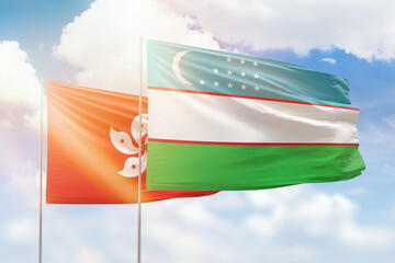 Sunny blue sky and flags of uzbekistan and hong kong
