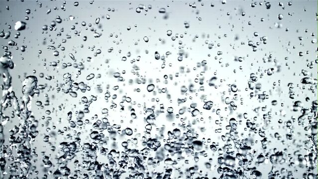 Water droplets rise up and fall down. On a white background. Filmed is slow motion 1000 fps.