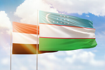 Sunny blue sky and flags of uzbekistan and yemen