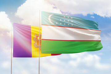 Sunny blue sky and flags of uzbekistan and andorra