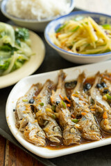 angle view fast food of steamed small fishes and cabbage and potato slices with rice vertical composition