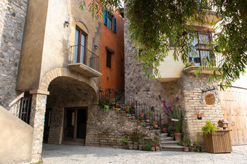 stairs going up between two old stone style building houses in a medieval italian tuscany villa in...