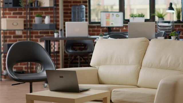 Nobody in empty business office with interior decorations, laptop and monitors to show statistics charts on display. No people in company workplace to create marketing analysis with graphs data.