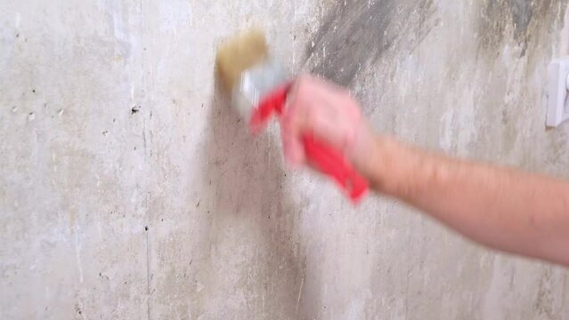 A man applies wallpaper glue with a brush for wallpapering. Repair of a room, apartment, house.