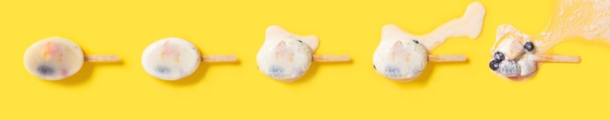 top view milk popsicle mixed with blackberry and blueberriess and mango slice and strawberry melting process on yellow background