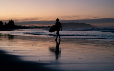 person walking on the beach at sunset