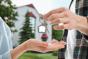 Man and woman with key from their new house outdoors