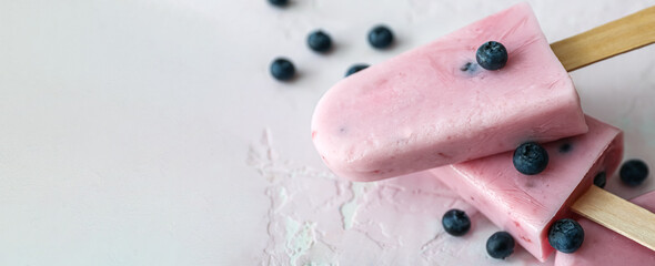 Tasty blueberry ice cream on light background with space for text