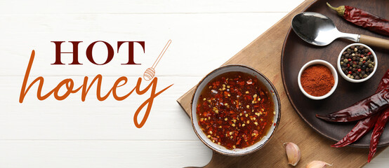 Composition with tasty hot honey and ingredients on white wooden background, top view