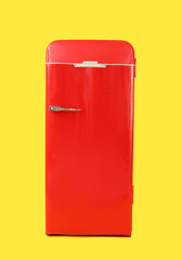 Stylish retro fridge on yellow background