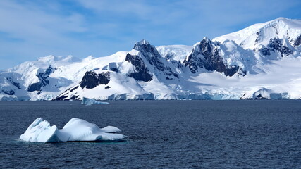 Iceberg floating in front of snow covered mountains at Portal Point, Antarctica