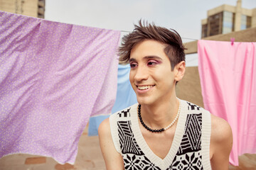 Retrato de joven latino gay mirando a un lado sonriente - obrazy, fototapety, plakaty