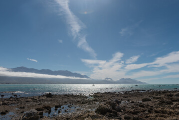 The view across the bay at Kaikoura from the peninsula to the Kaikoura Ranges. Two commercial fishing boats at anchor offshore. Kaikoura, Canterbury, South Island, New Zealand.