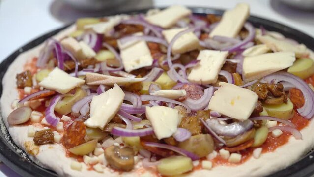 Pizzaiolo Putting Cheese On Top Of Red Onion Mushrooms And Potato