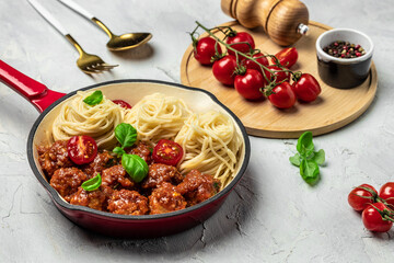 Meatballs served over italian spaghetti pasta with tomato sauce on a light background. Italian food. banner, menu, recipe place for text, top view