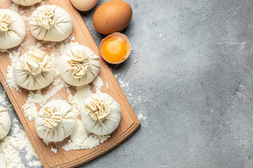Cutting board with raw khinkali with meat, semi-finished products dumplings. cooking khinkali. National Georgian cuisine. banner, menu, recipe place for text, top view