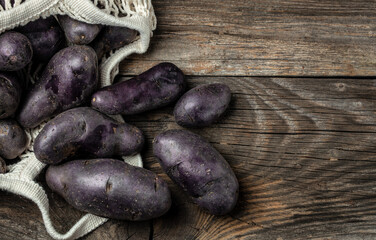 Raw sweet potatoes on wooden background, Organic purple sweet potato. Raw sweet potatoes or batatas. pomoea batatas. Batata potato, banner, menu, recipe place for text, top view