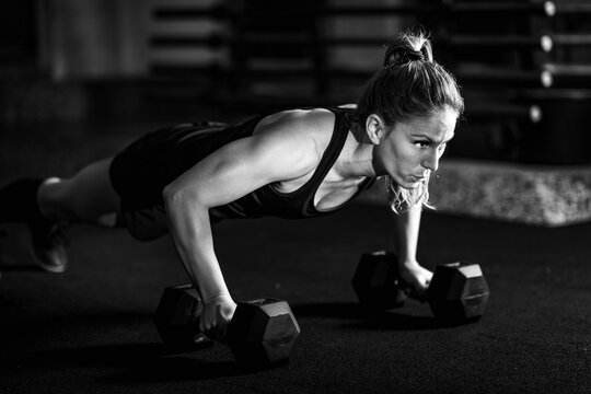 Cross training. Young woman exercising at the gym - Powered by Adobe
